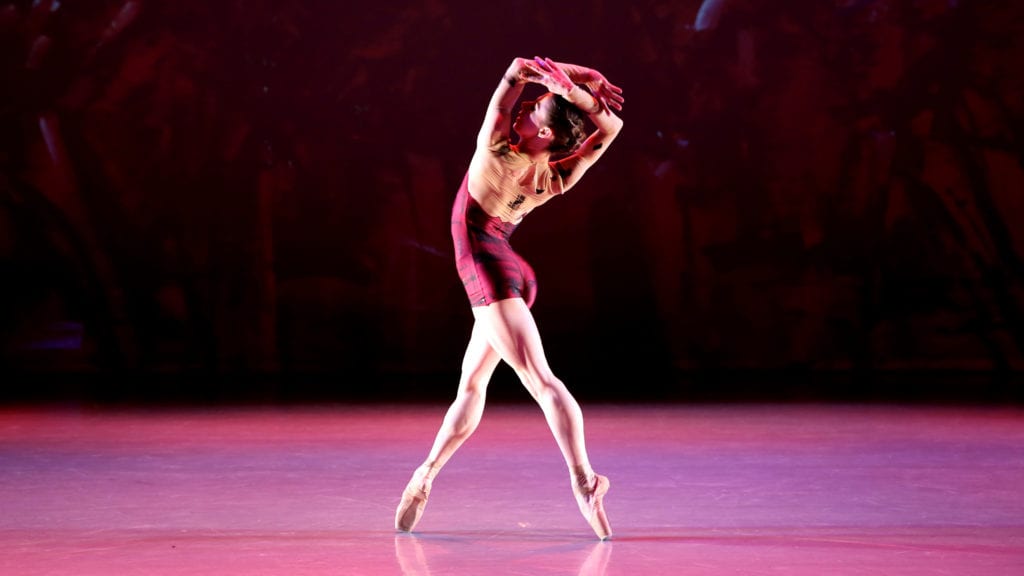 A single dancer has her arms overhead in "Figure in the Distance".